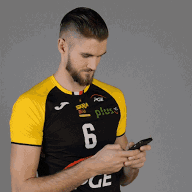 a man wearing a black and yellow jersey with the number 6 on it