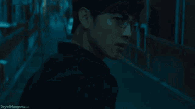 a man is walking down a dark alleyway and the words dryedmangoes.com are on the bottom of the screen