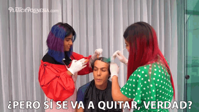 a woman with red hair is getting her hair dyed by two other women