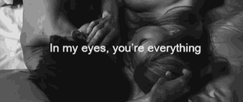 a black and white photo of a man and woman laying on a bed with the words in my eyes you 're everything