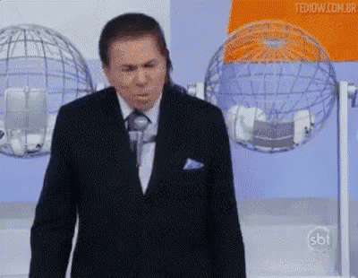 a man in a suit and tie is standing in front of a microphone in front of a globe .