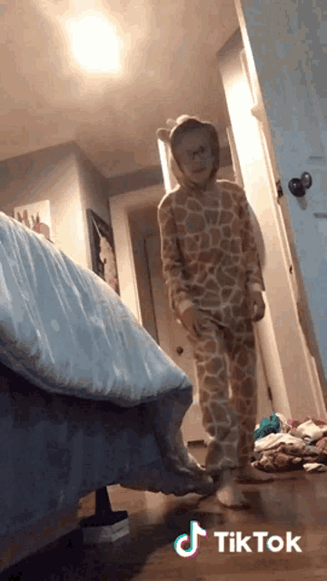 a girl in a giraffe pajamas is standing in a hallway with a tiktok watermark