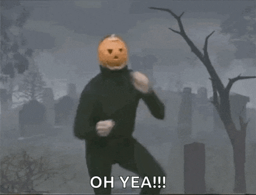 a man with a pumpkin on his head is dancing in a cemetery and says oh yea !