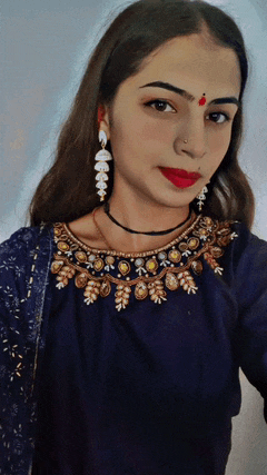 a woman with a red dot on her forehead is wearing earrings and a necklace