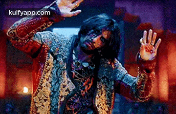 a man in a costume is dancing in a dark room with his hands outstretched .