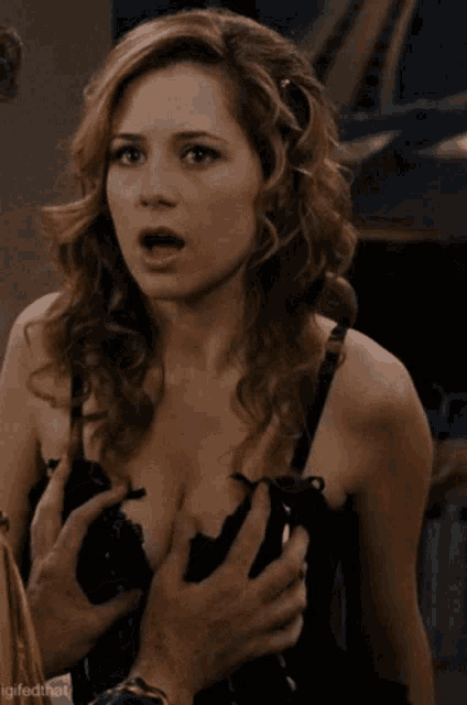 a woman in a black bra is being touched by a man 's hands