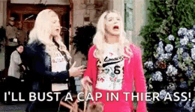 two women are standing next to each other and one of them is saying `` i 'll bust a cap in their ass '' .