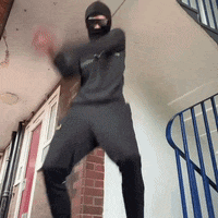 a man wearing a mask and sunglasses is standing on a set of stairs