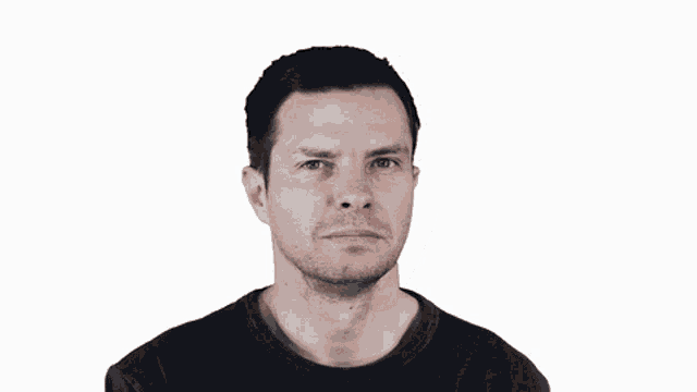 a man in a black shirt looks at the camera