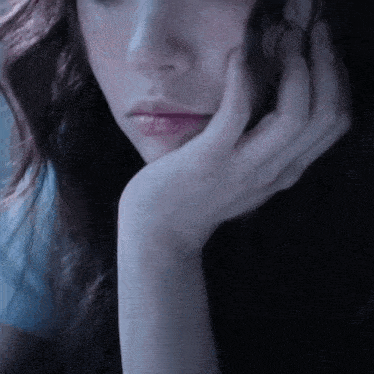 a woman with her hand on her face looks sad
