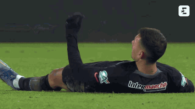 a soccer player is laying on the ground and his jersey says intermarche