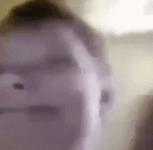 a blurry picture of a person 's face with a purple background .