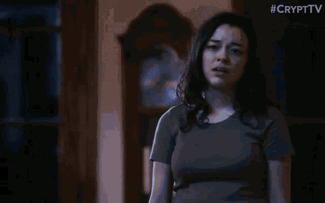 a woman is standing in a dark room with #crypttv written on the bottom right