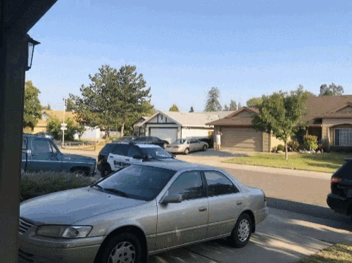 a silver car is parked in a driveway in a residential area
