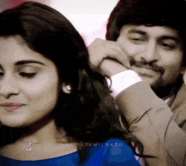 a man putting his hand on a woman 's shoulder with the name manifctamilnadu written on the bottom