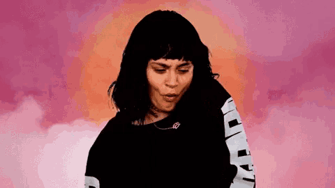 a woman with short hair is wearing a black shirt with white sleeves .