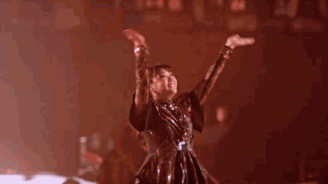 a woman in a black dress with her arms outstretched