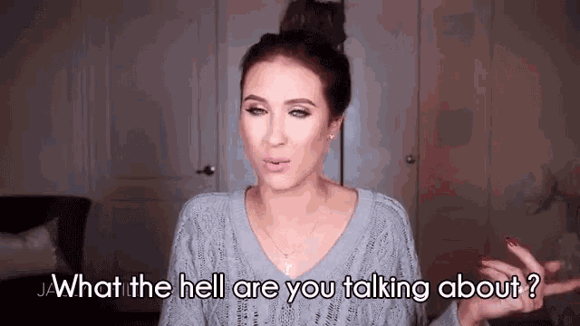 a woman in a gray sweater is talking to someone and asking what the hell are you talking about .