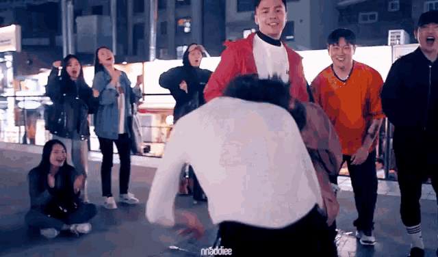 a group of people are dancing and one of them has the word ninja on the bottom of his shirt