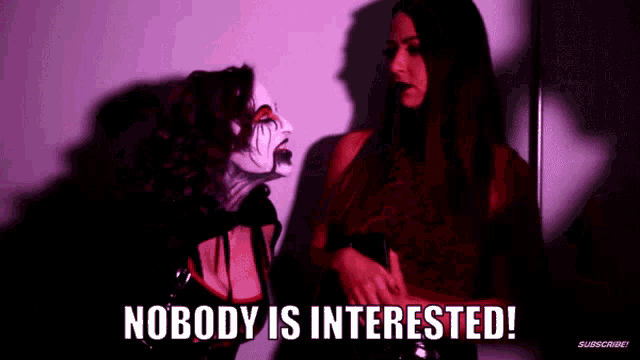 two women are standing next to each other in a dark room with the words nobody is interested written above them .