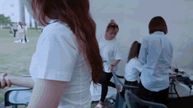 a group of women are standing in front of a white wall .