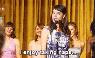 a woman singing into a microphone with the words " i enjoy taking naps " written below her