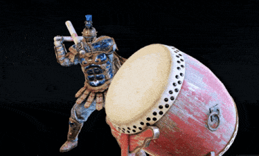 a statue of a man playing a drum with a sword