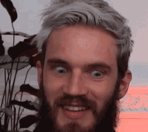 a man with a beard is making a funny face with his eyes closed .