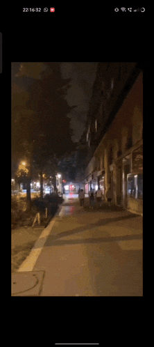 a blurry picture of people walking down a street at night .