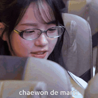 a woman wearing glasses is sitting on a plane with the words chaewon de marti written below her
