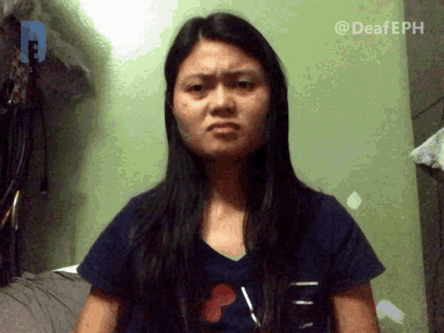 a woman wearing a shirt that says " i love you " looks angry
