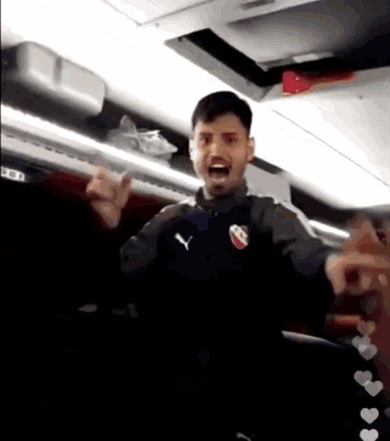 a man wearing a puma shirt is making a funny face