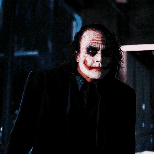 a man in a suit and tie with a clown face painted on his face
