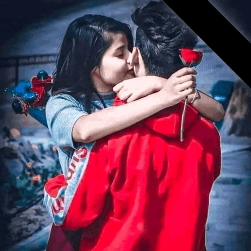 a man is holding a rose and a woman is kissing him .