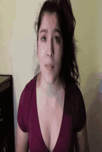 a woman in a purple shirt with a plunging neckline