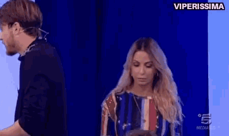 a man and a woman are standing in front of a blue wall with the words viperissima on the top