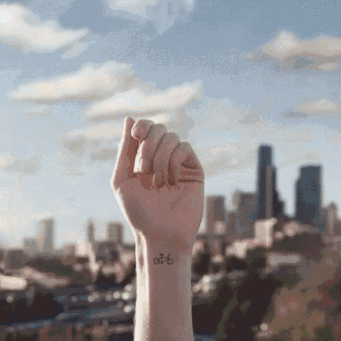 a person has a small tattoo on their wrist of a bicycle