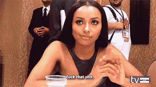 a woman is sitting at a table with a cup of water and says fuck that shit .
