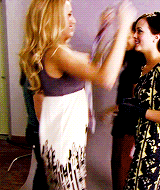two women are standing next to each other and one of them is wearing a white dress