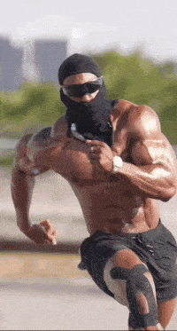 a shirtless muscular man wearing sunglasses and a black mask is running