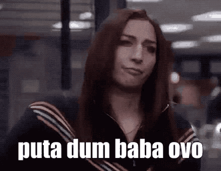 a woman with long hair is making a funny face and says puta dum baba ovo .