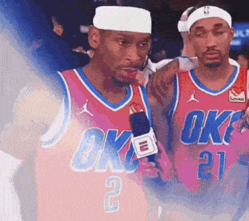 two basketball players wearing oklahoma city thunder jerseys are talking into microphones .