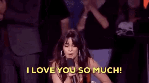 a woman in a red dress is holding a microphone and saying i love you so much .