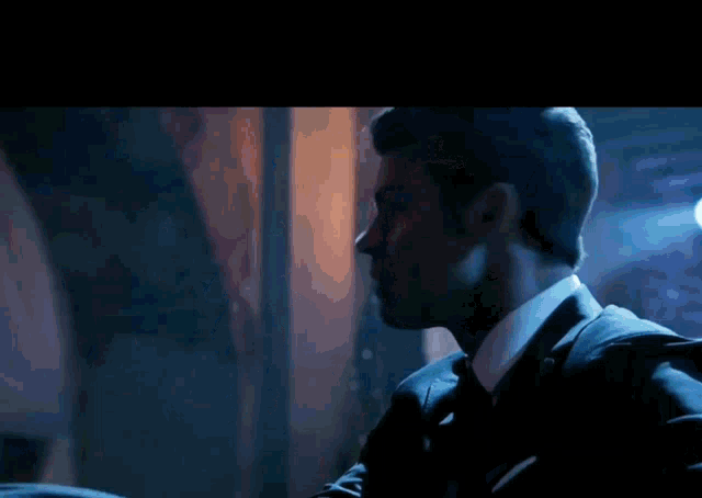 a man in a suit and tie is looking at something