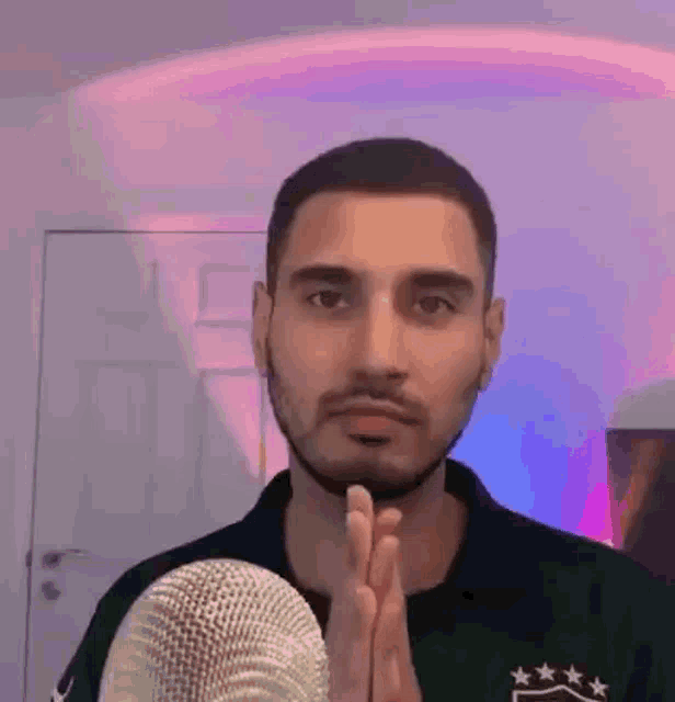 a man is praying in front of a microphone .