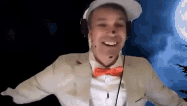 a man in a suit and bow tie is wearing headphones and smiling .