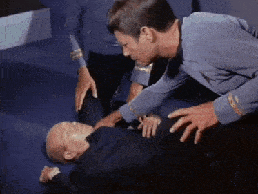 a man is laying on the floor with his hands on his stomach .