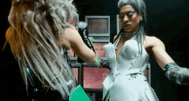 a man and a woman are standing next to each other in front of a mirror .