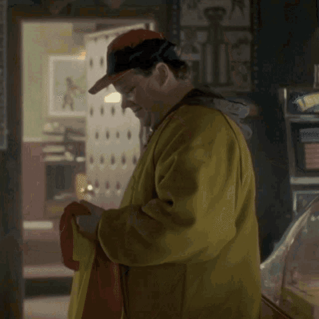 a man in a yellow jacket is standing in front of a machine that says ' x-pack ' on it