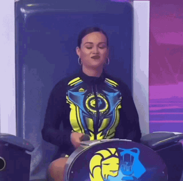 a woman is sitting in a chair with a microphone in her hand and making a funny face .